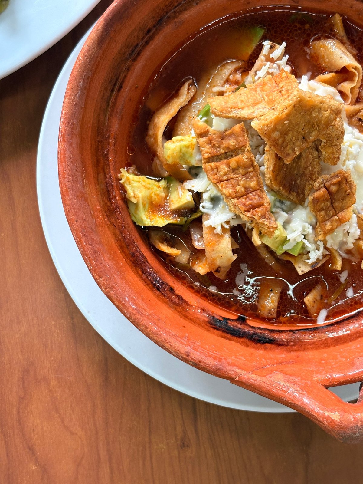 Sopa azteca con aguacate, crema, queso y chicharrón